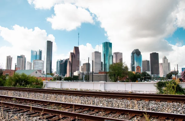 Houston downtown skyline with modern skyscrapers and railway tracks in foreground under cloudy sky