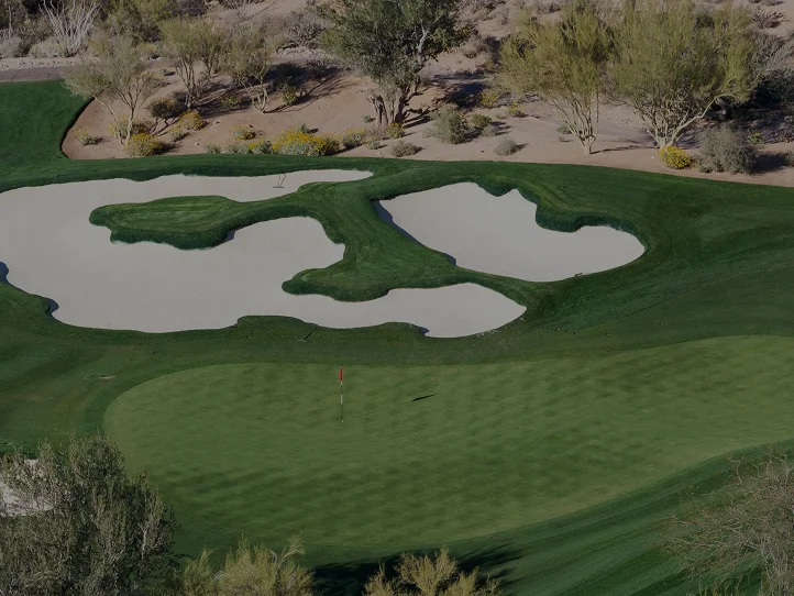 Pristine desert golf course in Scottsdale with manicured greens, sand bunkers and desert landscape