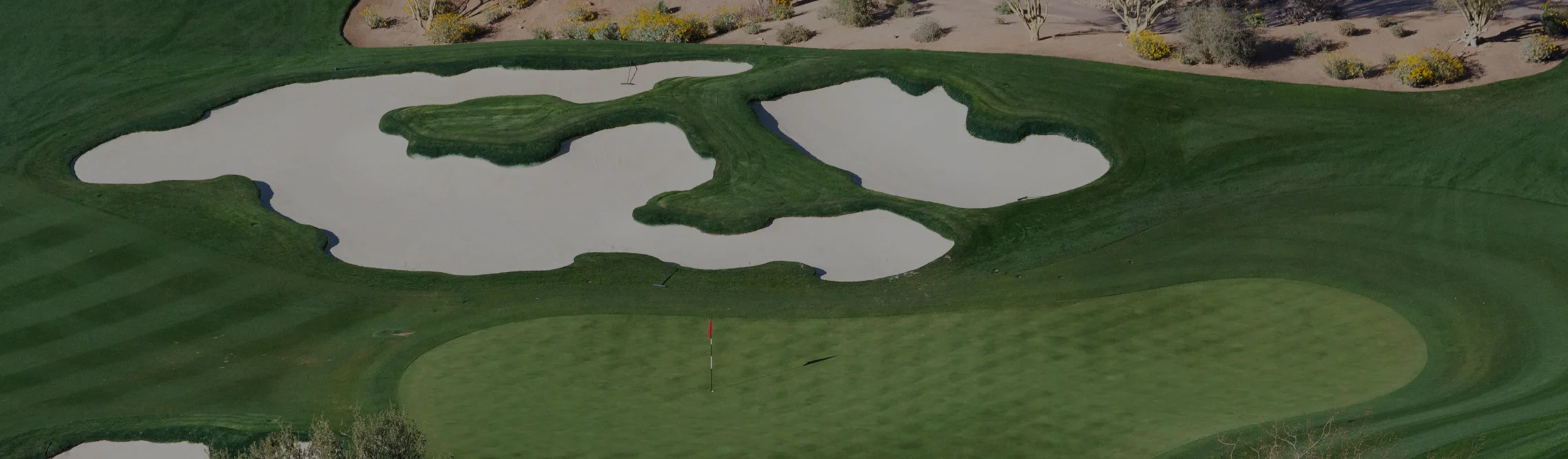 Pristine desert golf course in Scottsdale with manicured greens, sand bunkers and desert landscape
